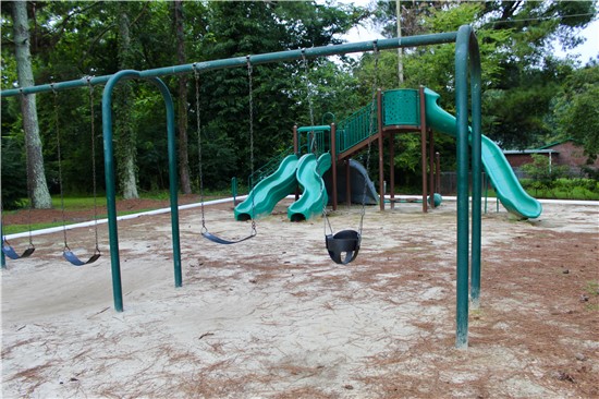 View of the swing sets and slides at the playground site